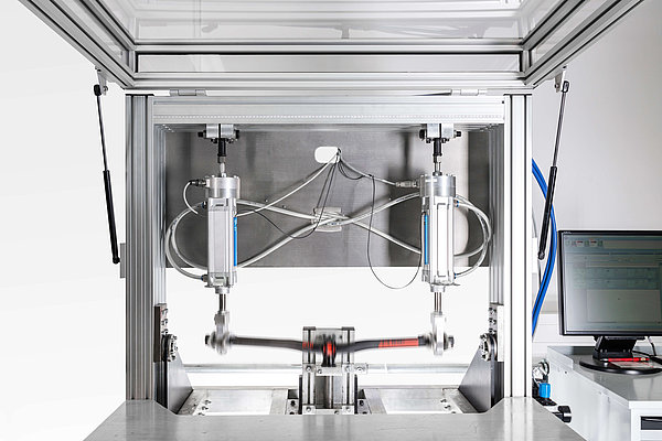 Ein Teststand für Fahrradlenker zeigt hydraulische Zylinder, die eine Lenkerstange in Bewegung setzen.