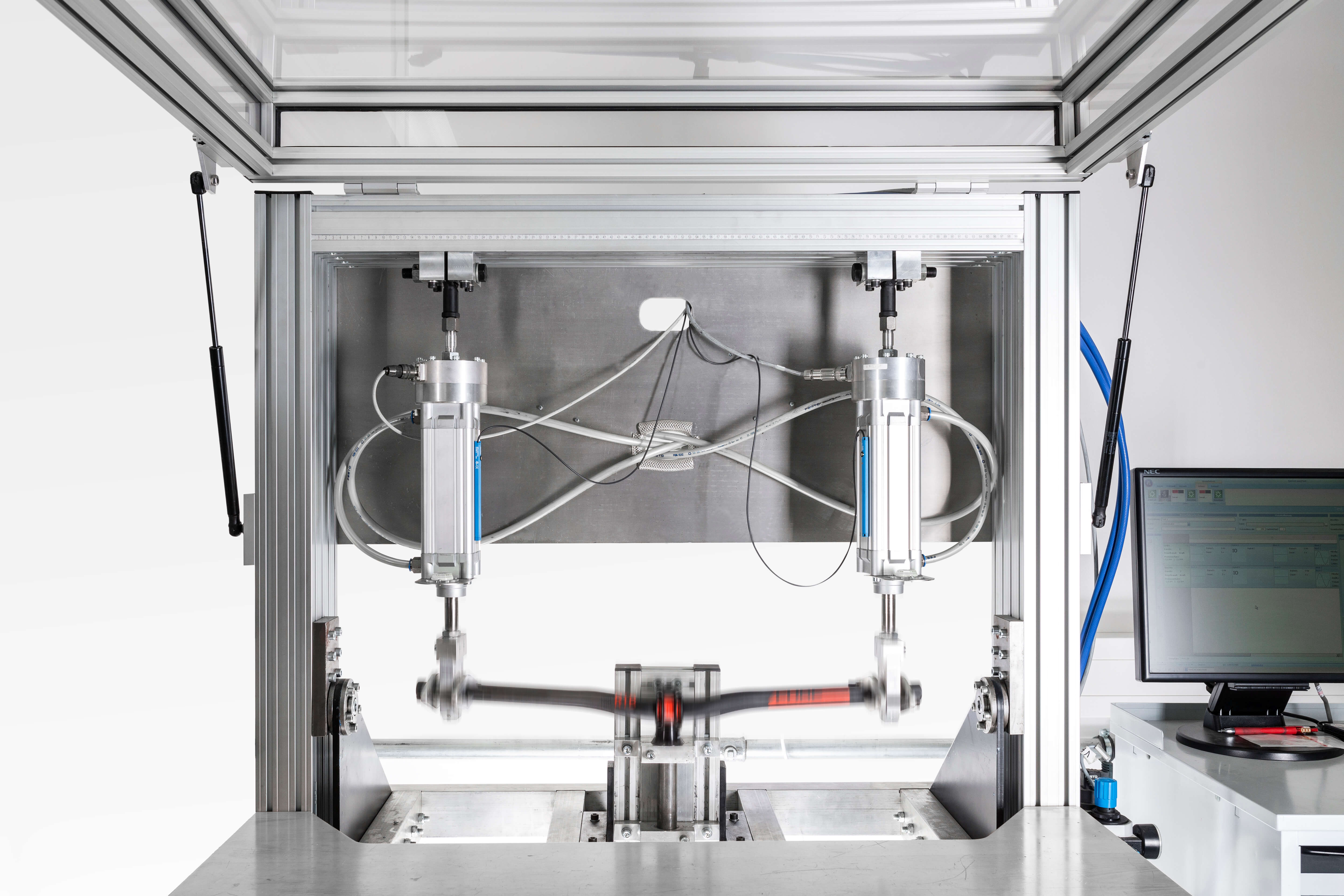 Ein Teststand für Fahrradlenker zeigt hydraulische Zylinder, die eine Lenkerstange in Bewegung setzen.